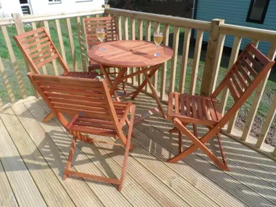 two chairs and a table with two glasses of wine at Luxury Mobile Home near Perranporth situated on a quiet farm in Truro