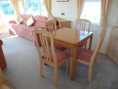 a wooden table and chairs in a living room at Luxury Mobile Home near Perranporth situated on a quiet farm in Truro
