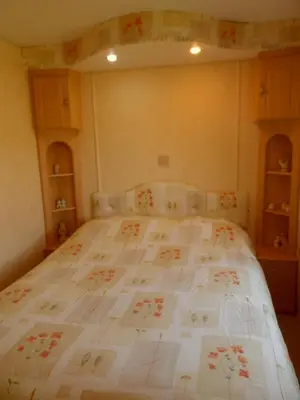 a bedroom with a large bed with a white comforter at Luxury Mobile Home near Perranporth situated on a quiet farm in Truro