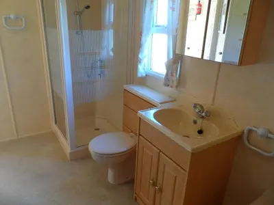 a bathroom with a toilet and a sink and a shower at Luxury Mobile Home near Perranporth situated on a quiet farm in Truro