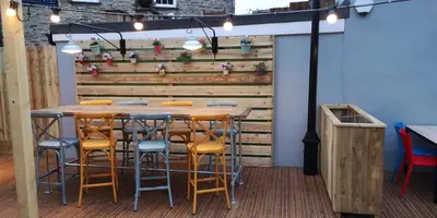 a bar with stools and a wooden wall at Barley Sheaf, Old Bridge Street EN SUITE ROOMS, ROOM ONLY in Truro