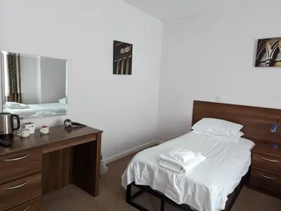 a bedroom with a bed and a desk and a mirror at Barley Sheaf, Old Bridge Street EN SUITE ROOMS, ROOM ONLY in Truro