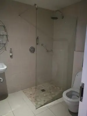 a shower with a glass door next to a toilet at Barley Sheaf, Old Bridge Street EN SUITE ROOMS, ROOM ONLY in Truro