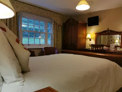 a bedroom with a white bed and a window at Rose in Vale Country House Hotel in St. Agnes