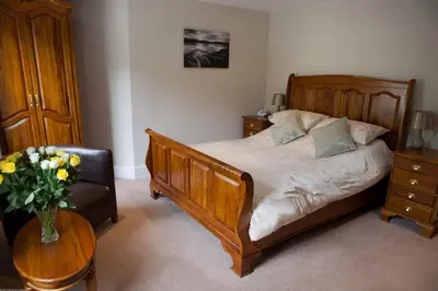 a bedroom with a bed and a vase of flowers on a table at Rose in Vale Country House Hotel in St. Agnes