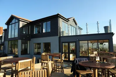 a patio with tables and chairs and a building at Widemouth Manor Hotel in Widemouth Bay