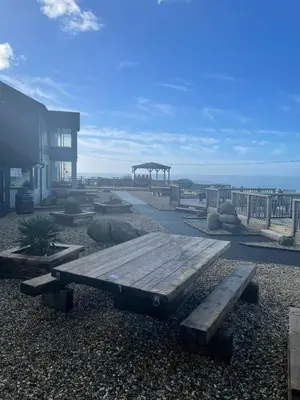 a wooden bench sitting in front of a building at Widemouth Manor Hotel in Widemouth Bay