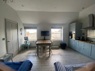 a kitchen with a table in the middle of a room at Little Dolly sea view 2 bedroom apartment, St Ives town, dog friendly in St Ives