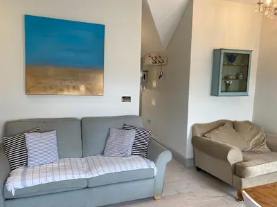 a living room with a couch and a chair at Little Dolly sea view 2 bedroom apartment, St Ives town, dog friendly in St Ives