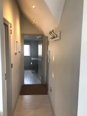 a hallway leading into a room with a stairway at Little Dolly sea view 2 bedroom apartment, St Ives town, dog friendly in St Ives