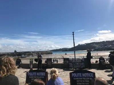a group of people watching a police officer on the beach at Little Dolly sea view 2 bedroom apartment, St Ives town, dog friendly in St Ives