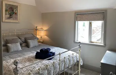 a bedroom with a bed and a window at Little Dolly sea view 2 bedroom apartment, St Ives town, dog friendly in St Ives