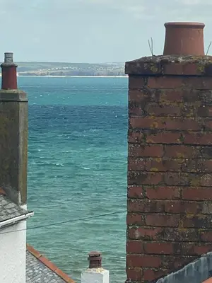 a view of the ocean from a brick building at Little Dolly sea view 2 bedroom apartment, St Ives town, dog friendly in St Ives