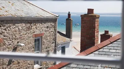 a view of the ocean from the balcony of a building at Little Dolly sea view 2 bedroom apartment, St Ives town, dog friendly in St Ives