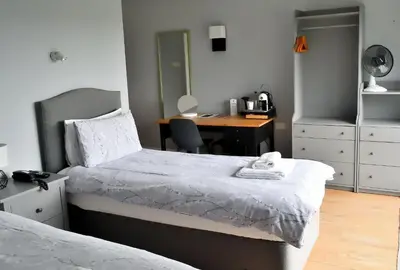 a bedroom with a bed and a desk with a chair at Bowood Park Hotel in Camelford