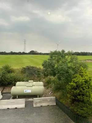 a gas tank sitting in a parking lot next to a field at Bowood Park Hotel in Camelford