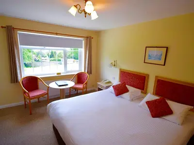 a hotel room with a large bed and a window at Penmere Manor Hotel in Falmouth