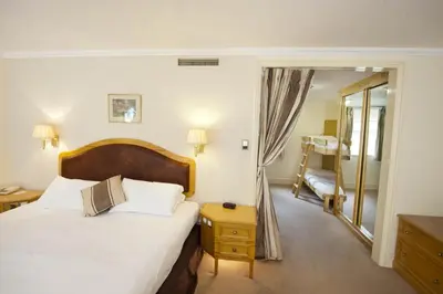 a bedroom with a large bed and a mirror at Penmere Manor Hotel in Falmouth