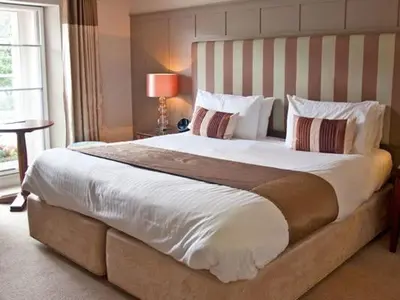 a bedroom with a large bed with a striped headboard at The Norway Inn in Perranwell