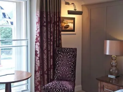 a room with a chair next to a window at The Norway Inn in Perranwell