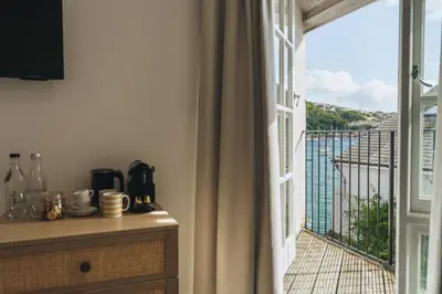 an open window with a view of a balcony at The Old Quay House Hotel in Fowey