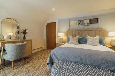 a bedroom with a bed and a desk and a chair at The Old Quay House Hotel in Fowey