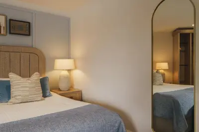 a bedroom with two beds and a mirror at The Old Quay House Hotel in Fowey