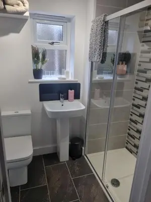 a bathroom with a toilet sink and a shower at Halwyn View in St Austell