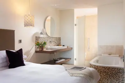 a hotel room with a bed and a bath tub at Scarlet Hotel - Adults Only in Mawgan Porth