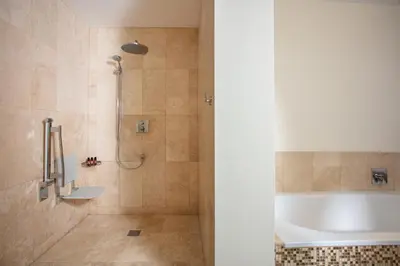 a bathroom with a tub and a shower stall at Scarlet Hotel - Adults Only in Mawgan Porth