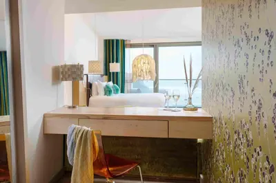 a bedroom with a bed and a desk with wine glasses at Scarlet Hotel - Adults Only in Mawgan Porth