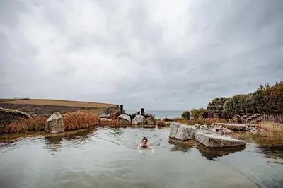 a woman is swimming in a pool in a river at Scarlet Hotel - Adults Only in Mawgan Porth