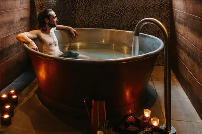 a man sitting in a large copper bath tub at Scarlet Hotel - Adults Only in Mawgan Porth