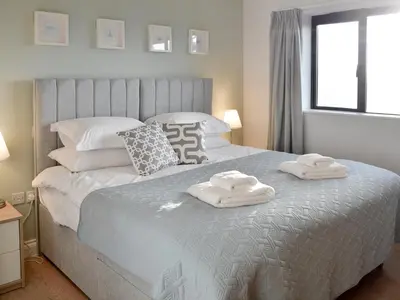 a bedroom with a bed with towels on it at Lyndhurst in Perranporth