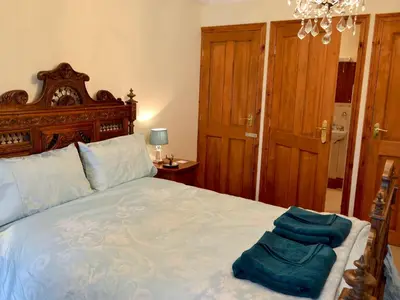 a bedroom with a large bed with blue sheets at Trevellyan Barn in Lanivet