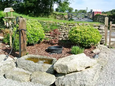 a garden with rocks and a stone wall at Trevellyan Barn in Lanivet
