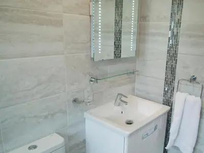 a bathroom with a sink and a toilet and a mirror at Moonrakers in Ruan Lanihorne