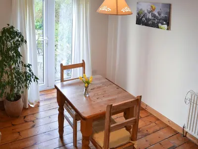 a dining room table with a vase of flowers on it at Little Lookover in Saint Columb Minor