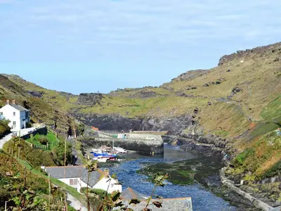 a river in a valley with boats in it at Knights Den in Port Isaac