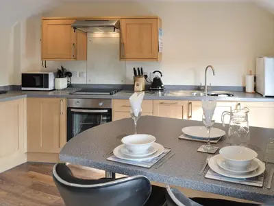 a kitchen with a table with chairs and a sink at Knights Den in Port Isaac