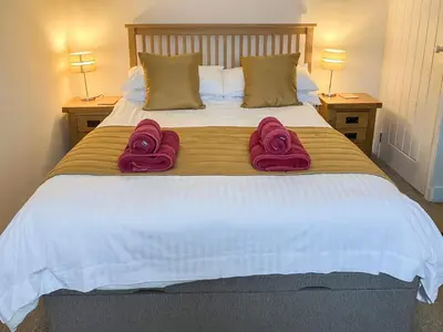 a bedroom with a bed with two towels on it at Knights Den in Port Isaac