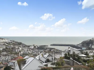 a view of a town with the ocean in the background at Penfose Apartment in Mevagissey