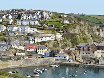 a town on a hill with boats in the water at Penfose Apartment in Mevagissey