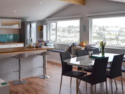 a kitchen and dining room with a table and chairs at Penfose Apartment in Mevagissey