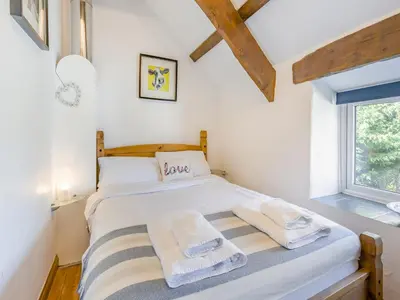 a bedroom with a bed with towels on it at Jarvies Cottage in Boscastle