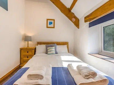 a bedroom with a bed with towels on it at Jarvies Cottage in Boscastle