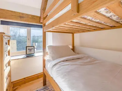 a bedroom with a bunk bed and a window at Jarvies Cottage in Boscastle