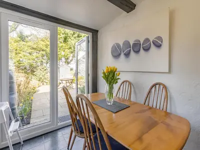 a dining room with a wooden table and chairs at Jarvies Cottage in Boscastle