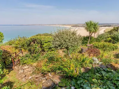 a view of a beach with trees and plants at Studio Sea Urchin in Carbis Bay