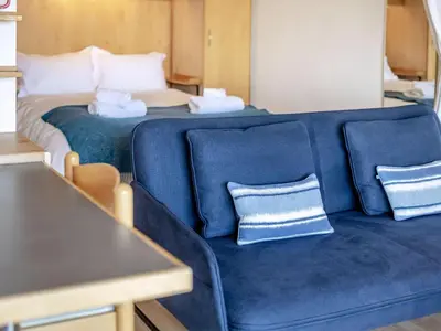 a blue couch with two pillows in a room at Studio Sea Urchin in Carbis Bay